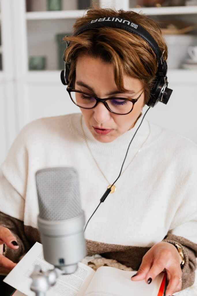 Photo of Woman Reading Book While Wearing Headphones